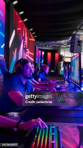diverse pro gamer blue team with boy leader competing in video game esport championship - premiere of vertical entertainments in darkness arrivals stockfoto's en -beelden