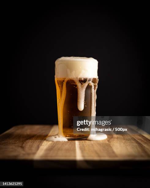 close-up of beer on table against black background,slovenia - vaso de una pinta fotografías e imágenes de stock