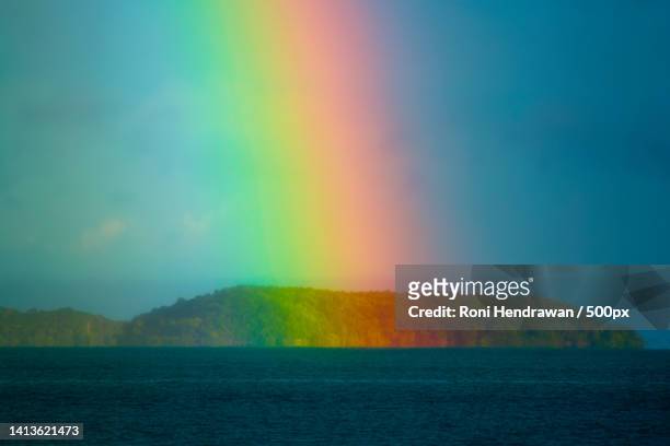 scenic view of rainbow over sea against sky,indonesia - hendrawan stock pictures, royalty-free photos & images
