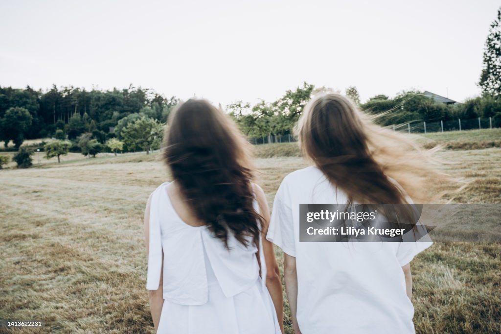 Mother and daughter with long hair, view from the back, blurred motion.
