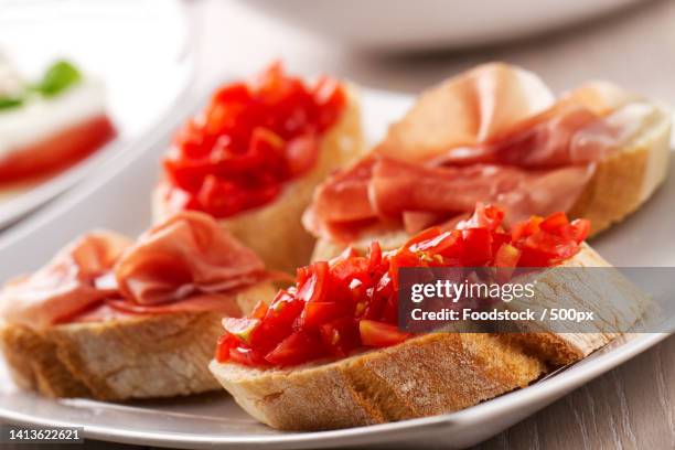 italian appetizer bruschetta with parma ham on a plate - crostini stock pictures, royalty-free photos & images