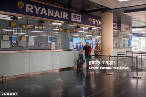 Two people walk past a Ryanair window at Josep Tarradellas Barcelona-El Prat Airport on August 8 in Barcelona, Catalonia, Spain. New days of strike...