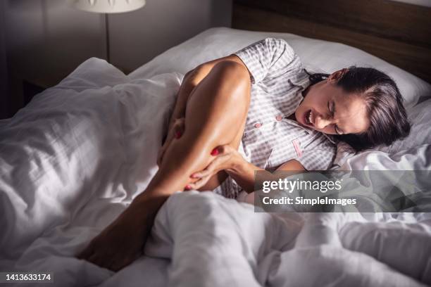 a woman got severe cramps in her calf at night while sleeping. - wade menschliches körperteil stock-fotos und bilder