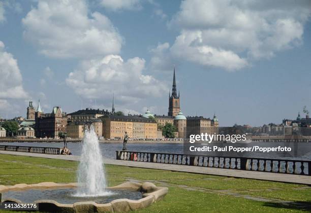 Visitors seated beside a balustrade in Stadshusparken City Hall gardens on Kungsholmen island in central Stockholm, capital city of Sweden circa...