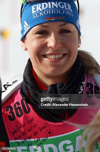 Magdalena Neuner of Germany smiles at a private note attached to her bib from her team mate Miriam Goessner during training session for the IBU Wolrd...