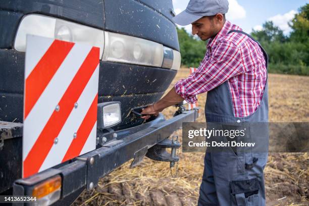 ein traktorfahrer arbeitet an seinem traktor. - bartstoppel stock-fotos und bilder