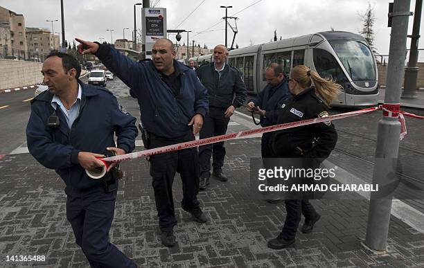 Policeman sections off the crime scene with tape at a train station in Jerusalem after a young female Israeli soldier was stabbed by a man suspected...
