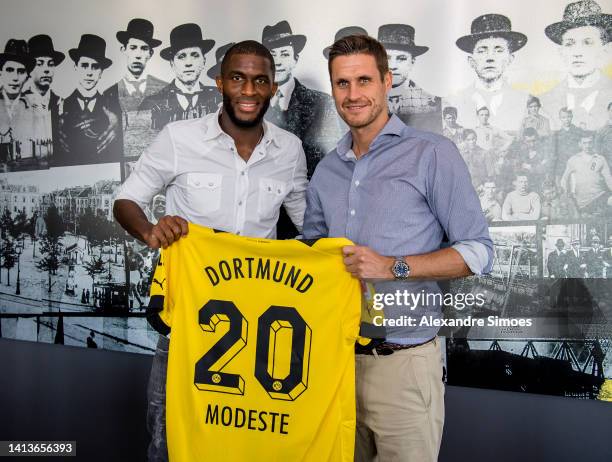 Newly signed player of Borussia Dortmund Anthony Modeste and Sebastian Kehl, sporting director of Borussia Dortmund, pose on August 08, 2022 in...