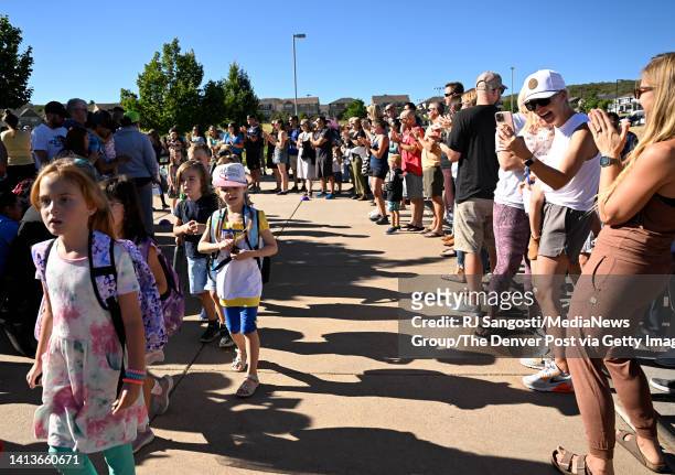 Parents line the walkway outside Clear Sky Elementary, in the Douglas County School District, to cheer for the students as they head into School for...