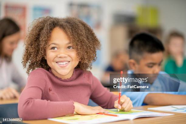 elementary student writing in class - basisschool student stockfoto's en -beelden