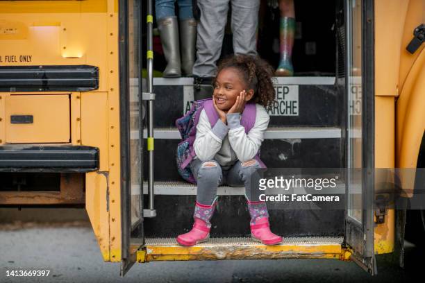elementary student posing on a bus step - kids sitting together in bus stock pictures, royalty-free photos & images
