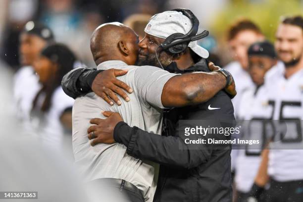 Defensive line coach Brentson Buckner of the Jacksonville Jaguars hugs Bryant Young prior to the 2022 Pro Football Hall of Fame Game against the Las...