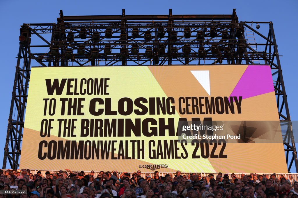 Closing Rites Spectators sit under a screen welcoming them to the Closing Ceremony ...