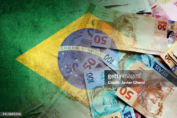 brazilian reais cash bills and flag of brazil - produit intérieur brut photos et images de collection