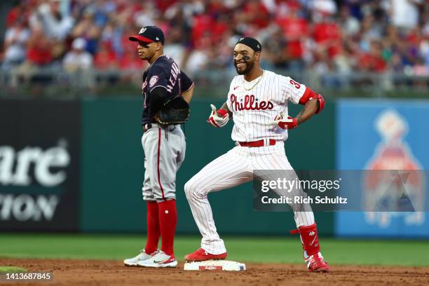 Edmundo Sosa of the Philadelphia Phillies gestures after he hit an RBI double as second baseman Cesar Hernandez of the Washington Nationals looks on...