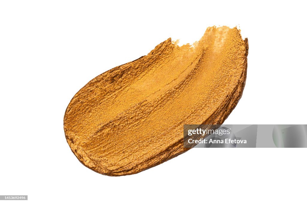 Golden glittering smear of suntan lotion isolated on white background. Concept of healthy lifestyle and skincare. Macrophotography with copy space for your design