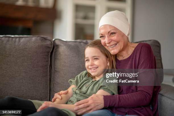 cancer patent cuddling with her granddaughter - kids cancer smile stock pictures, royalty-free photos & images