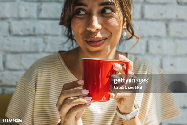 young woman holding red coffee cup - cup lip stockfoto's en -beelden