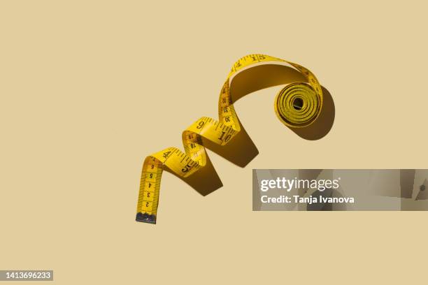 measuring tapes on beige background - measuring stockfoto's en -beelden