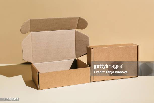 brown cardboard boxes on beige background, copy space - new stock photos et images de collection