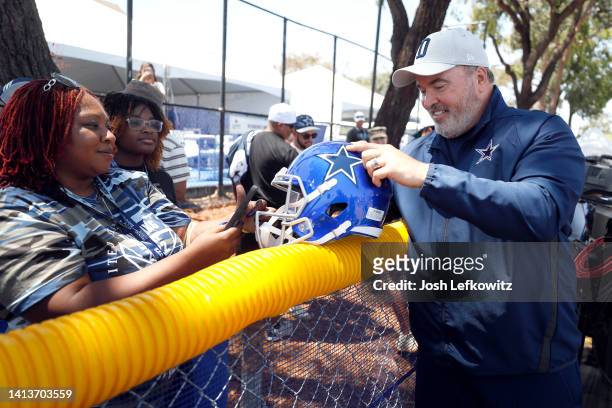 Head coach Mike McCarthy of the Dallas Cowboys signs autographs after training camp at River Ridge Fields on August 08, 2022 in Oxnard, California.