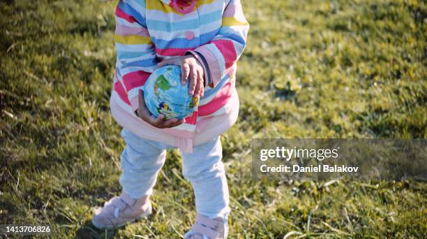 safe the earth. baby plays with globe ball in nature at sunset. - annual legacy stock pictures, royalty-free photos & images