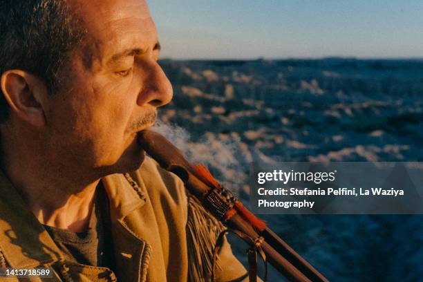 mature mas smoking sacred pipe - smoking pipe stock pictures, royalty-free photos & images