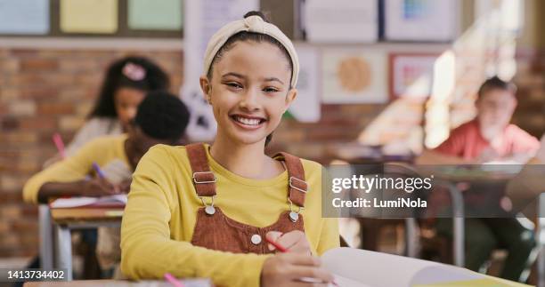 young, smiling and happy school girl writing notes in class. elementary student learning and taking down information with excitement. education and gaining knowledge through creativity and fun - image technique stock pictures, royalty-free photos & images