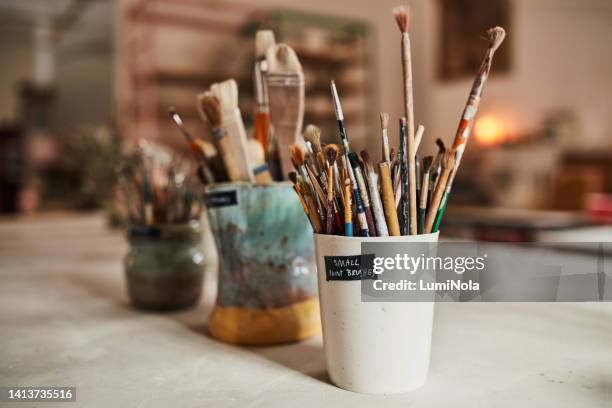creative paintbrush tools, equipment or objects for colorful and modern artwork, design and painting in an art studio or workshop. jar or container of many different paint brushes in an empty room - jar stock pictures, royalty-free photos & images