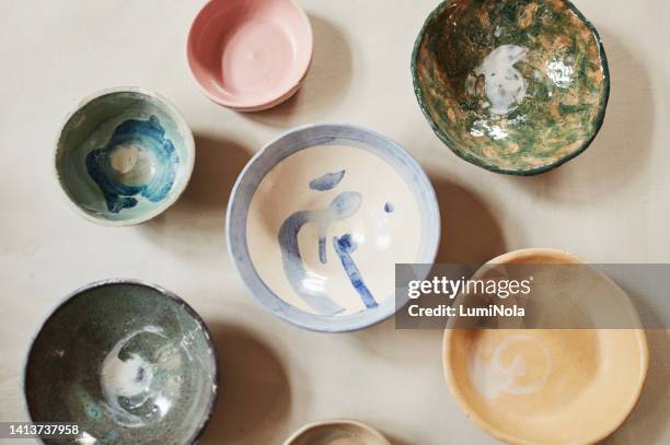 traditional japanese bowls from an overhead view on a table with a unique design and texture. many antique, vintage and old dishes of different round sizes in a kitchen counter - porslin bildbanksfoton och bilder