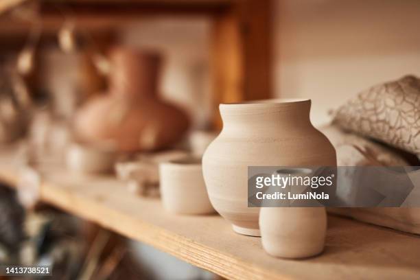 pottery, ceramic and handmade products on a shelf in a workshop and showroom. closeup of clay vases and earthenware on display in a craft store. variety of finished clayware in a small business - vase stock pictures, royalty-free photos & images