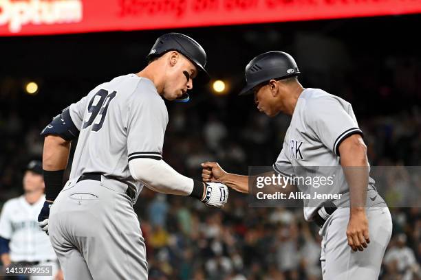 Aaron Judge of the New York Yankees shakes hands with third base coach Luis Rojas after hitting a solo home run during the ninth inning against the...