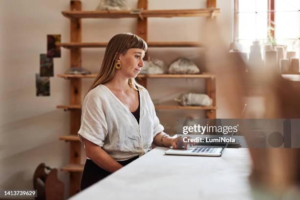 creative business woman browsing, searching the internet and reading emails on a laptop in office alone at work. one professional, expert and serious designer looking for ideas and working at a desk - bossy stock pictures, royalty-free photos & images