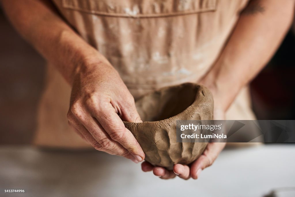 Fabricante de cerámica, artista o diseñador moldeando y construyendo un objeto con arcilla en una fábrica, estudio o clase de arte. Trabajador, ceramista o alfarero creando, diseñando o haciendo una estructura en un taller