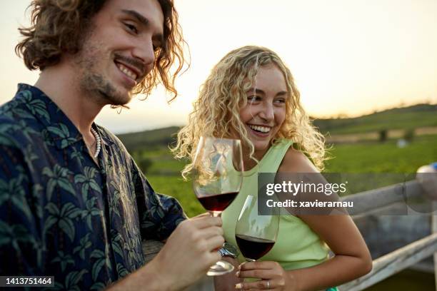 smiling young couple enjoying outdoor wine tasting - wine enjoyment stock pictures, royalty-free photos & images