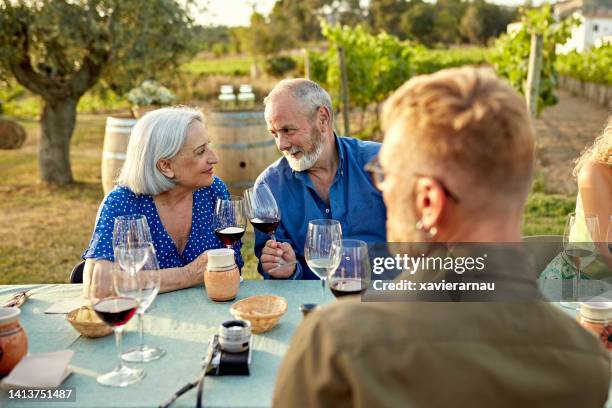 pareja de ancianos disfrutando de una cata de vinos en vacaciones - tradición fotografías e imágenes de stock