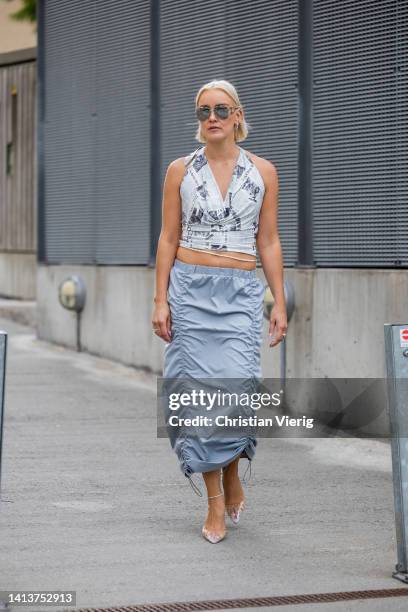 Tina Haase is seen wearing Nakd newspaper print Top, Freja wewer Nylon low waist skirt, Chanel sunglasses, Mango vinyl heels on August 08, 2022 in...
