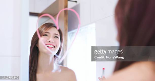 woman in front of mirror - lipstick heart stock pictures, royalty-free photos & images