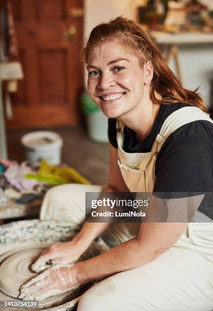 happy potter making pottery on a potters wheel in a workshop or class modeling the clay. portrait of a craftswoman enjoying her hobby shaping a sculpture into an art mold or creation - pottery making stock pictures, royalty-free photos & images