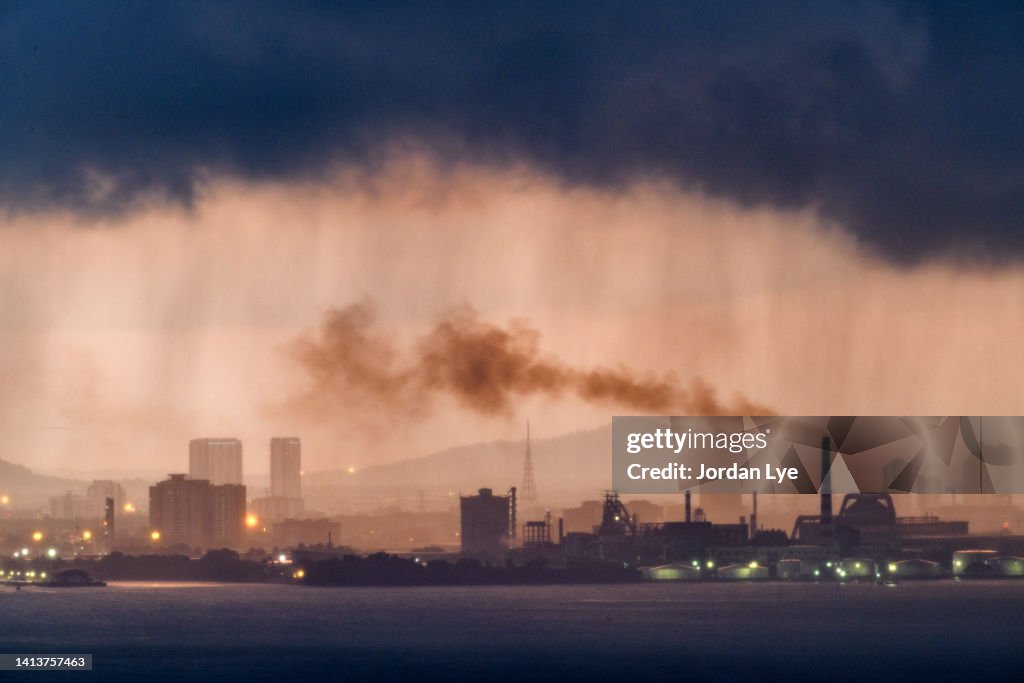 Dramatic sunrise and rain over industrial area