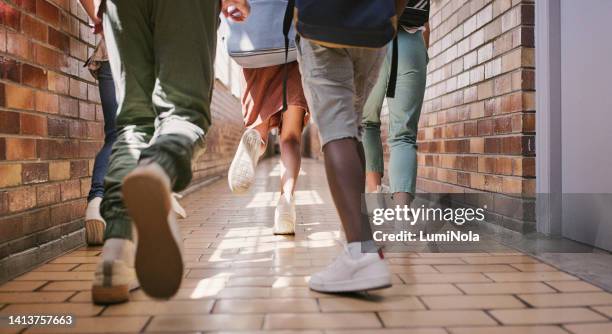 späte und aktive schulkinder, die auf dem weg zum unterricht in einem flur oder einer bildungseinrichtung laufen oder gehen. niedrige winkelfüße einer gruppe junger, kleiner studenten, die in der pause eilen oder spielen gehen - 12 feet 5 stock-fotos und bilder