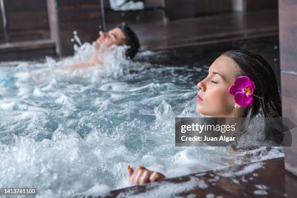 young relaxed couple lying in hot tub in spa resort - hot latina women 個照片及圖片檔