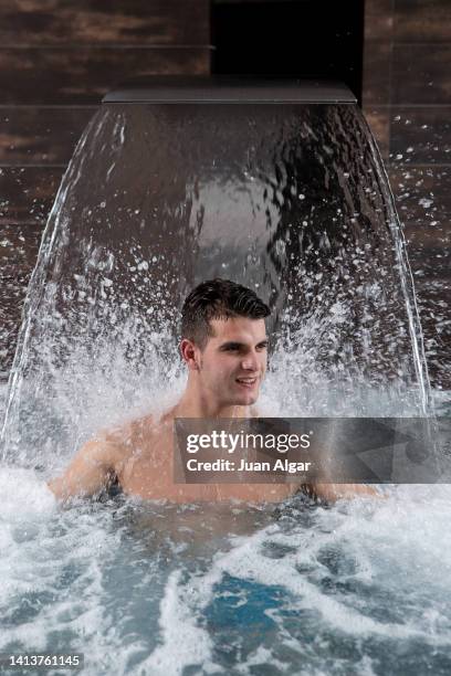 content fit guy relaxing in swimming pool under waterfall - algar waterfall spain stock pictures, royalty-free photos & images