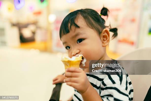 positive emotion asian baby girl happy to eating ice cream first time and cream messy on her mouth - hot dirty girl stock pictures, royalty-free photos & images