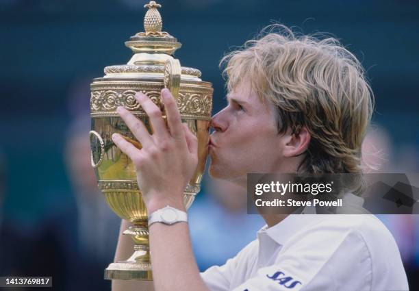 Stefan Edberg from Sweden kisses the Gentlemen's Singles Championship Trophy after defeating Boris Becker of Germany in their Men's Singles Final...