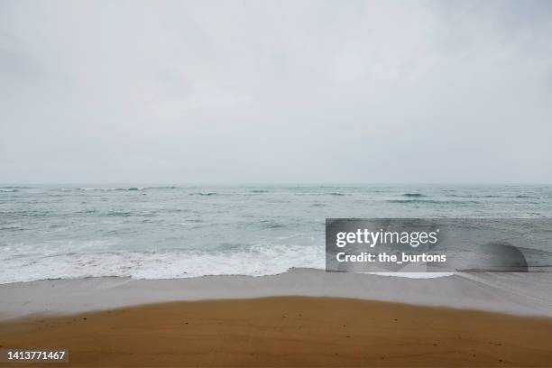 beach, sea and overcast sky - grey overcast stock pictures, royalty-free photos & images