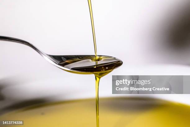 a spoonful of olive oil - olio da tavola foto e immagini stock