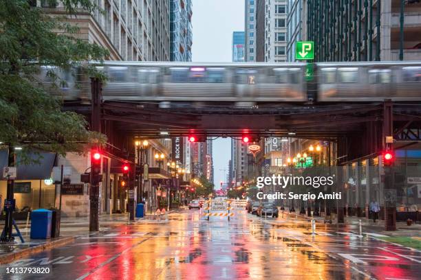 chicago l train with colourful stop lights and traffic lights reflected on wet road - chicago illinois sign stock pictures, royalty-free photos & images