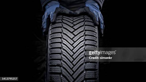 männerhände schieben reifen - tire stock-fotos und bilder