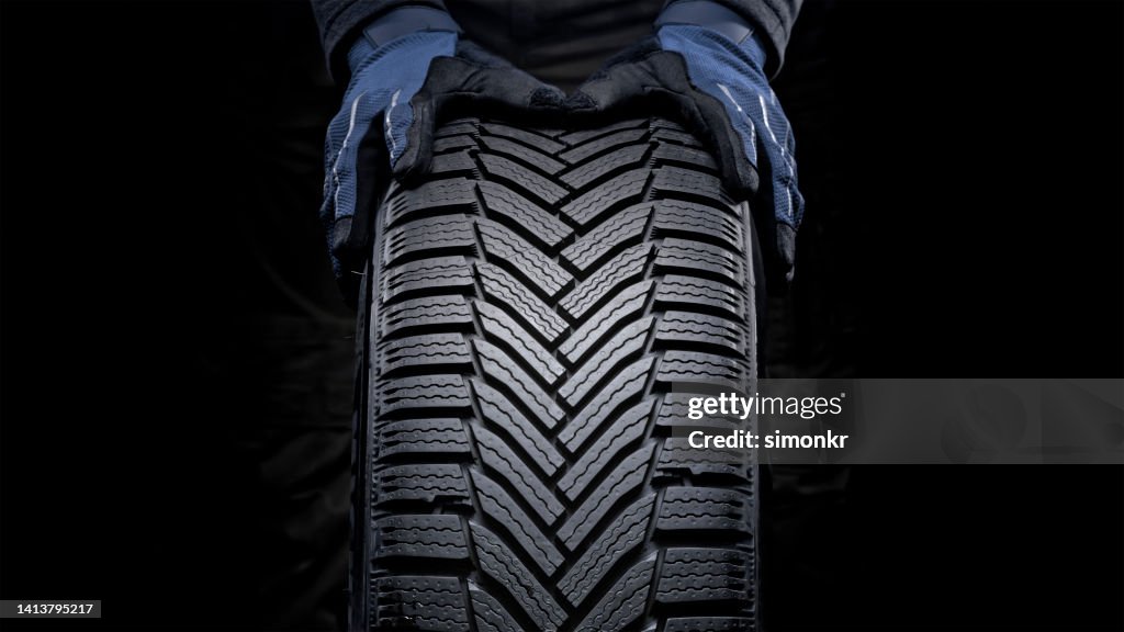 Les mains de l’homme poussant le pneu